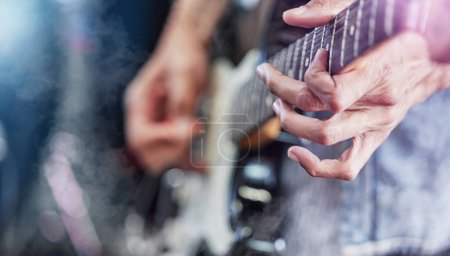 Téléchargez les photos : Guitare, scène et mains d'homme au festival de musique montrent jouer du rock avec un instrument électrique avec des lumières. Son, musicien et fête avec talent live et audio pour un événement punk avec des gens lors d'un concert. - en image libre de droit