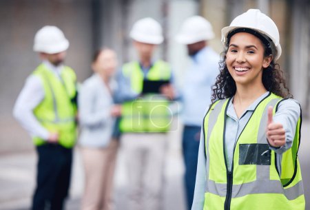 Photo for Thumbs up, woman construction worker and at a industrial workplace happy with her colleagues in the background. Thank you or success, agreement and cheerful or excited architect at building site. - Royalty Free Image