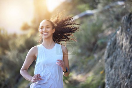 Photo for Happy woman, running and smile in forest for fitness, workout or cardio exercise in the outdoors. Fit, active or sporty female person or runner smiling for healthy wellness, run or training in nature. - Royalty Free Image