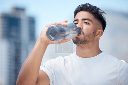 Photo for Man, fitness and drinking water in city workout, cardio exercise or running for sustainability outdoors. Thirsty male person, athlete or runner with drink for hydration, rest or break in urban town. - Royalty Free Image