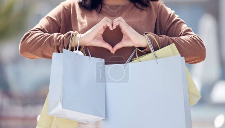 Photo for Heart hands, person and shopping bags from fashion clothing discount, deal and sale. City, woman and emoji hand sign with love for retail purchase, style payment and boutique in town at mall. - Royalty Free Image