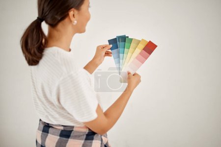 Photo for Renovation, woman and wall colours with chart at home with creativity for interior design. Female designer, thinking and colour card for paint for a house with guide for idea with maintenance - Royalty Free Image