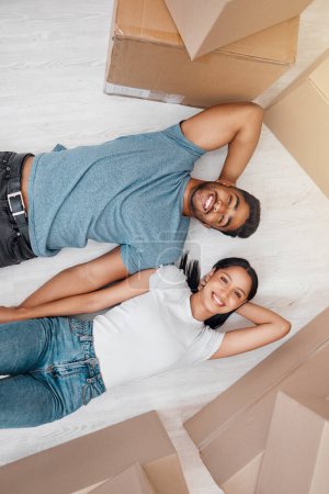 Photo for Top view, home and couple with boxes, apartment and excited on the floor, mortgage and relationship. Portrait, man and woman on the ground, cardboard and excited with new house, moving in and growth. - Royalty Free Image