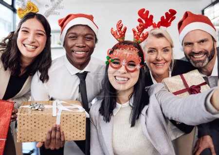 Téléchargez les photos : Amis, selfie et hommes d'affaires à la fête de Noël au bureau avec des accessoires stupides. Diversité, sourire et collègues d'entreprise heureux de prendre des photos avec des cadeaux lors de la célébration festive - en image libre de droit