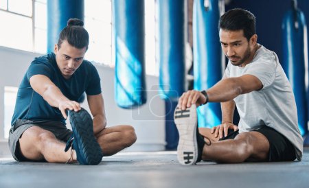 Photo for Men, gym and legs stretching of friends before training, fitness and workout in health club. Warmup, athlete and man ready to start sport exercise together on the floor with personal trainer class. - Royalty Free Image