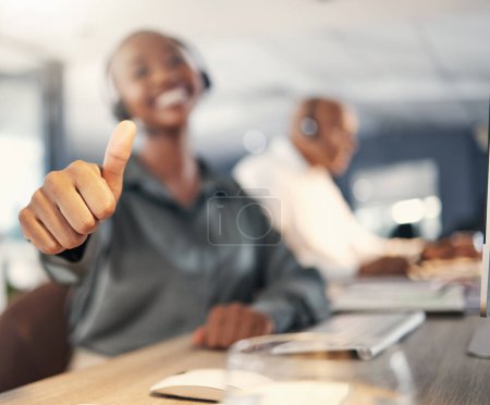 Photo for Thank you, African woman with thumbs up and headset at her workplace in a office for success. Congratulations or support, telemarketing or crm and call center agent with emoji hand for motivation. - Royalty Free Image