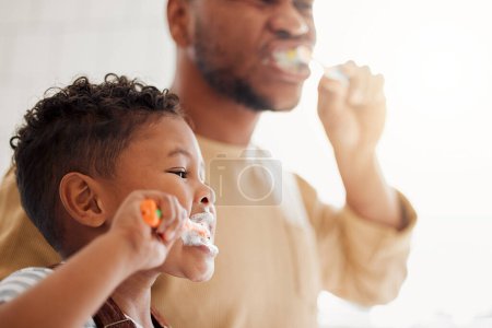 Foto de Cepillarse los dientes, el niño y el papá en un baño en casa para la salud y el bienestar dental. Cara de un hombre y un niño africano aprendiendo a limpiar la boca con un cepillo de dientes y pasta de dientes para la higiene bucal y el autocuidado. - Imagen libre de derechos