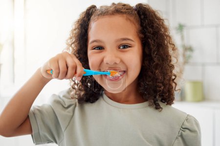 Photo for Toothbrush, brushing teeth and portrait of a child in a home bathroom for dental health and wellness with smile. Face of Latino girl kid learning to clean her mouth for morning routine and oral care. - Royalty Free Image