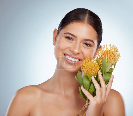 Photo for Face, skincare and happy woman with flowers in studio isolated on a white background. Portrait, natural and female model with floral pincushion protea plants for makeup, cosmetics or beauty treatment. - Royalty Free Image