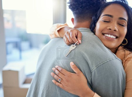 Photo for Happy couple, hug and real estate with key for moving in new home or mortgage loan together indoors. Woman hugging man with smile in happiness, property or investment with keys to apartment building. - Royalty Free Image