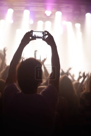 Photo for Streaming, concert and hands of audience with phone for pictures, celebration and enjoying stage, music or event. Party, people and performance with excited fans showing support, passion or recording. - Royalty Free Image