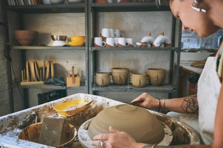 Téléchargez les photos : Moins il y a de bosses, mieux c'est. une jeune femme travaillant avec de l'argile dans un atelier de poterie - en image libre de droit