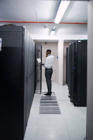 Photo for Looking for areas to improve. a young male technician working in a server room - Royalty Free Image