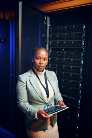 Photo for A business cant thrive with poor connections. Portrait of a young woman using a digital tablet while working in a server room - Royalty Free Image