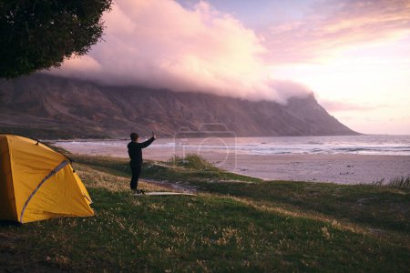 Téléchargez les photos : Cette vue est fascinante. une jeune femme séduisante campant à son spot de surf préféré - en image libre de droit