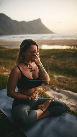 Photo for Paying attention to my body. Full length shot of an attractive young yogi sitting alone and putting pressure on the third eye pressure point - Royalty Free Image