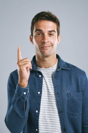 Photo for I told you this would happen. a man pointing up against a grey background - Royalty Free Image