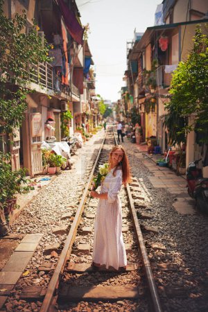 Foto de Viviendo mi propia felicidad para siempre. una joven caminando en las vías del tren por las calles de Vietnam - Imagen libre de derechos