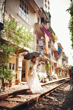 Foto de Lugares para ir, una vida para vivir. una joven caminando en las vías del tren por las calles de Vietnam - Imagen libre de derechos