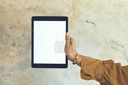 Photo for Target a big audience by advertising online. Closeup shot of an unrecognisable woman holding a digital tablet with a blank screen against a wall - Royalty Free Image