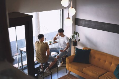 Foto de Sólo necesitaba a alguien con quien hablar. dos jóvenes hablando mientras toman un café juntos en un café - Imagen libre de derechos
