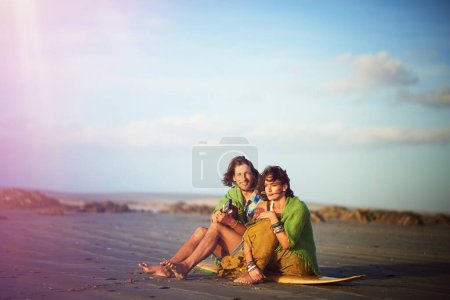 Photo for Heres that song I wrote you. a young man playing the guitar while sitting on the beach with his girlfriend - Royalty Free Image