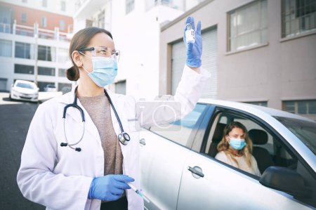 Photo for Pull up and be a part of the vaccine program. a masked young doctor giving a patient an injection at a Covid-19 drive through testing centre - Royalty Free Image