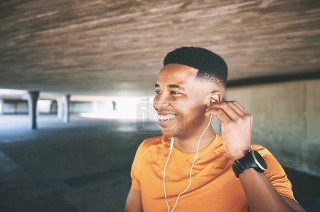 Photo for Awesome workout music from start to finish. a young man using earphones during his workout against an urban background - Royalty Free Image