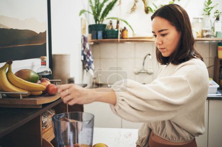 Photo for This smoothie is going to be delicious. a young woman using her blender to make a smoothie - Royalty Free Image