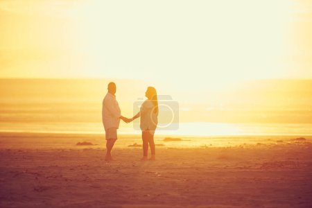 Foto de El paraíso está donde quiera que estés. Largura completa de una pareja madura cariñosa de pie cara a cara y mano en mano en la playa - Imagen libre de derechos