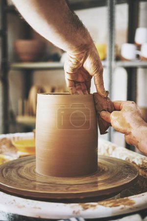 Téléchargez les photos : Le temps est limité, faire plus d'art. un homme méconnaissable travaillant avec de l'argile dans un atelier de poterie - en image libre de droit