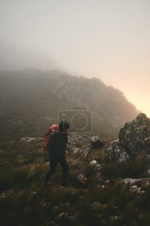 Foto de Vengo a las montañas cuando me siento estresado. un hombre vistiendo su mochila mientras estaba fuera para una caminata en las montañas - Imagen libre de derechos