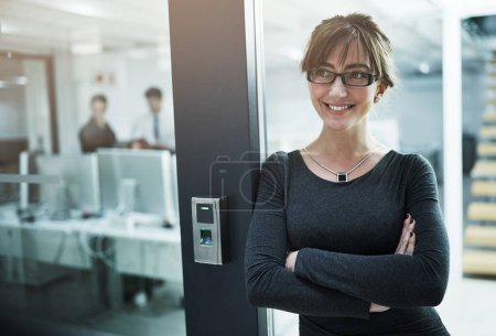 Photo for Shes got an open door policy. a young businesswoman standing with her arms crossed in an office doorway - Royalty Free Image