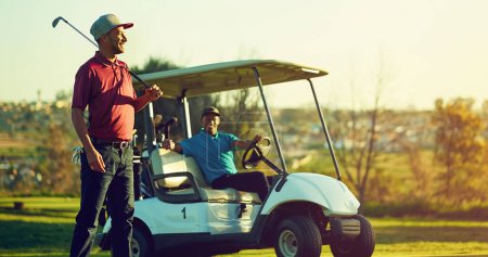 Foto de Es compatible con cualquiera. un golfista sosteniendo su club con un buggy borroso en el fondo - Imagen libre de derechos