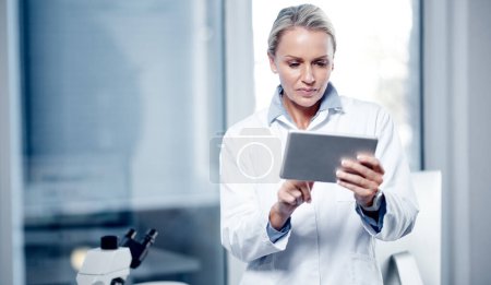 Photo for Processing scientific data on her device. a mature scientist using a digital tablet while working in her lab - Royalty Free Image