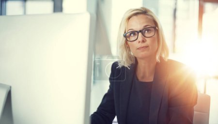 Photo for Shes got that ceo vision. a thoughtful businesswoman working at her desk in a modern office - Royalty Free Image