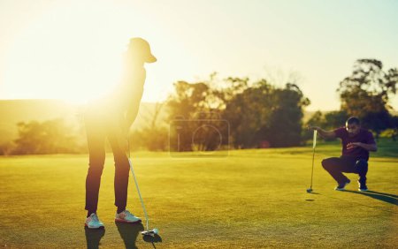 Téléchargez les photos : Prenez la vie une chance à la fois. deux amis jouant une partie de golf sur un terrain de golf - en image libre de droit