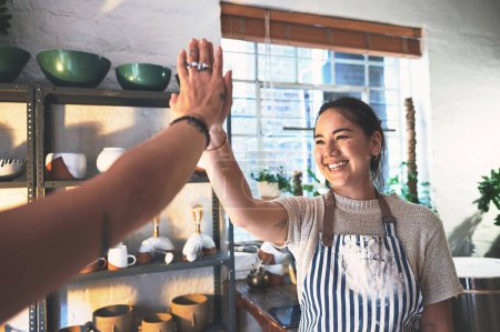 Photo for Whats art without passion. two young women giving each other a high five in a pottery studio - Royalty Free Image