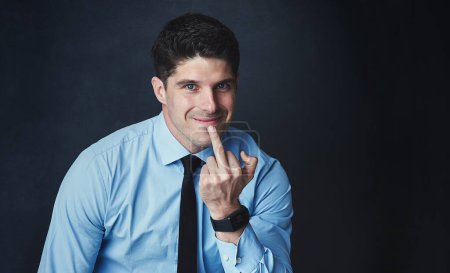 Photo for Could you kindly flip off out of my way. Studio portrait of a young businessman showing the middle finger against a dark background - Royalty Free Image