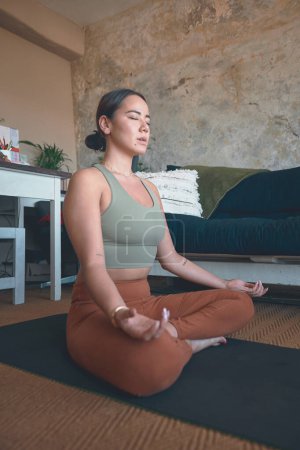 Foto de La vida se trata de encontrar el equilibrio. una joven meditando mientras practica yoga en casa - Imagen libre de derechos
