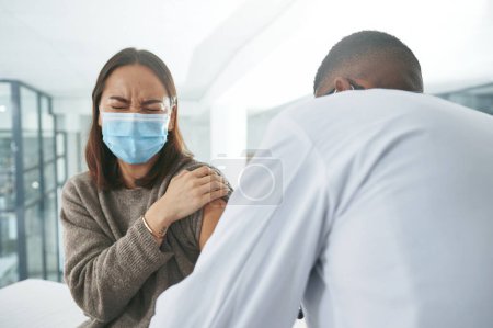 Photo for I hate needles. an unrecognizable doctor giving a patient an injection in an office - Royalty Free Image
