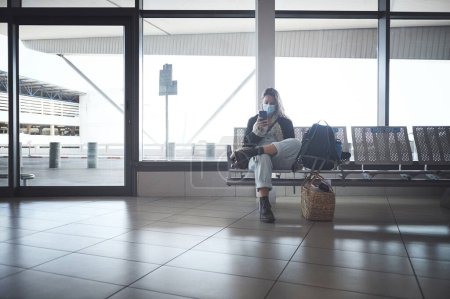 Photo for How long is this layover. Shot a young woman sitting with a bags in the airport - Royalty Free Image