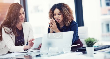 Photo for Their tool of choice for team tasks. two businesswomen using a digital tablet together during a collaboration at work - Royalty Free Image