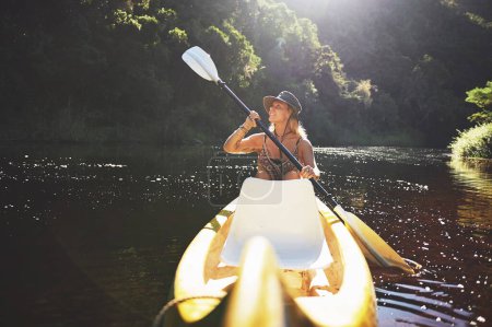 Foto de Lo hago para acercarme a la naturaleza. una joven mujer en kayak en un lago - Imagen libre de derechos