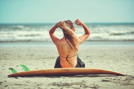 Téléchargez les photos : Shell est là où sont les vagues. une belle jeune femme qui va surfer sur la plage - en image libre de droit