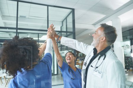 Photo for We started together and well finish together. a diverse group of healthcare professionals standing and giving each other a high five - Royalty Free Image