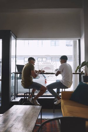 Foto de Tomaré tu número para que podamos hacer esto de nuevo. dos jóvenes tomando café juntos en un café - Imagen libre de derechos