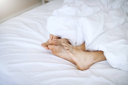 Foto de Es tan acogedor estar en la cama contigo. una pareja de pies mientras yacen juntos en la cama - Imagen libre de derechos