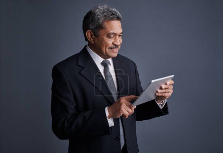 Photo for Making smart moves is easier with a smart device. Studio shot of a mature businessman using his digital tablet - Royalty Free Image