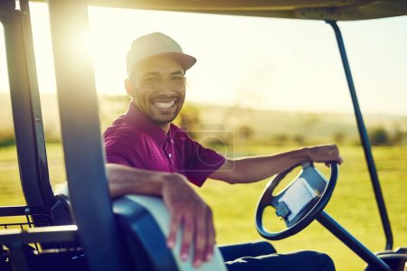 Téléchargez les photos : Prêt pour une superbe partie de golf. Portrait d'un jeune homme heureux conduisant une voiturette sur un terrain de golf - en image libre de droit